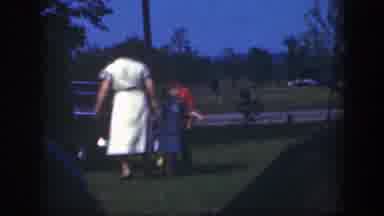 Massachusetts (1949): A Woman Plays With Two Kids In A Grassy Parking Lot
