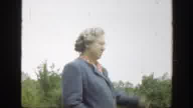 Massachusetts (1949): Woman Wearing Gray Coat Hits Ball With Wooden Stick On A