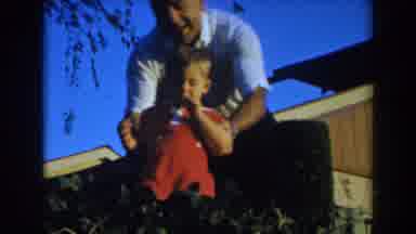 Glendale California (1962): Man Lifting Little Kid Over Hedge So He Can Walk On