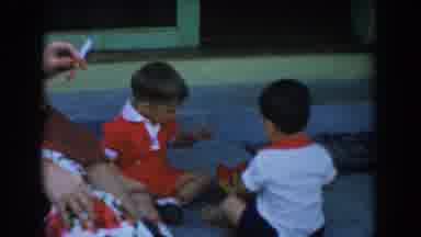 Glendale California (1962): Two Toddlers Play With Red And Yellow Object On A