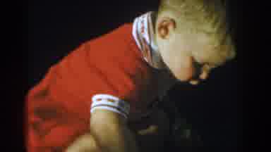 Glendale California (1962): Toddler Wearing Red Romper Picks Up Small Toys On A