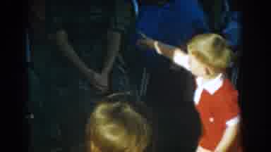 Glendale California (1962): A Kid Entertaining A Group Of Adults As A Woman Bends