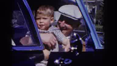 Glendale California (1962): Man Wearing White Hat Holds Toddler Wearing Blue And