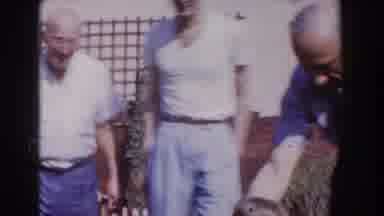 Glendale California (1962): Man Wearing Blue Shirt Gives White Object To Toddler