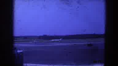 Copenhagen Denmark (1975): A High-Tail Jet Aircraft Taxis Down A Runway With Trees