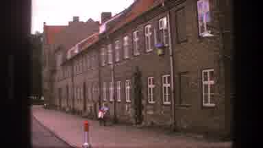 Copenhagen Denmark (1975): A Lone Walker Walks Past A Parked Car Besides A Large