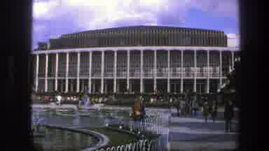 Copenhagen Denmark (1975): People Walking In Front Of A Large Building That Has A