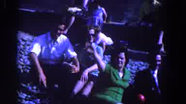 Ireland (1961): Woman In Green Shirt Sitting On Ground Waves To Camera Near A