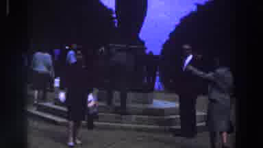 Ireland (1961): Small Crowd Gathers Around Black Object On A Clear Day
