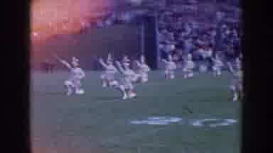 Nebraska-1957: A Color Guard Team On A Football Field Performing For A Crowd