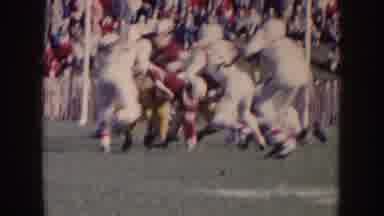Nebraska (1957): People Watch Football Players Playing A Football Game Outside