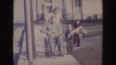 Nebraska (1957): Family With Father In Wheelchair Talking A Walk On Street On Cold