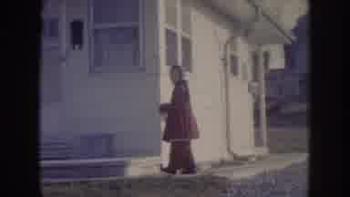 Nebraska (1957): A Young Girl In A Red Outfit Stands In Front Of A Home A Woman