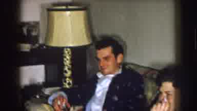Nebraska (1957): Men And Women Sitting On Couches And Furniture In House Looking