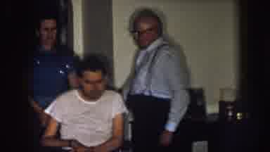 Nebraska (1957): Man And Woman Standing In Front Of A Man In A Wheelchair