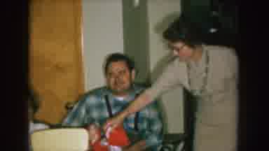 Nebraska (1957): A Guy On A Wheelchair Holding Some Toys And A Woman Near Then