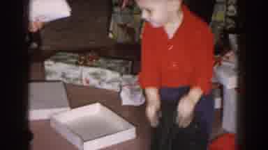 Nebraska (1957): Man Wearing White Shirt Helps Toddler Wearing Red Shirt Open