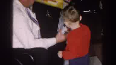 Nebraska (1957): Toddler Wearing Red Shirt Drops Toy Red Car Onto Brown Floor