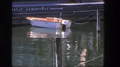 Denmark (1975): A Little Boat On A River With Reflection Of People Walking And A