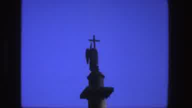 Denmark (1975): View Of Dark Gray Crucifix Against Blue Sky On A Clear Day