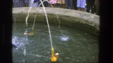 Denmark (1975): Women And Men Watch Mechanical Ducks Circle In The Pool Of A