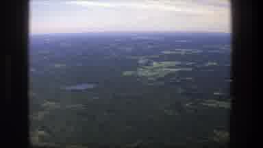Denmark (1975): Aerial View Of Green Trees And Small Blue Lake On A Hazy Day
