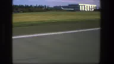 Denmark (1975): The View Of A Building With An Airplane Parked Outside Through A