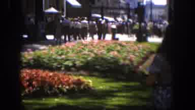 Wyoming (1951): Woman Wearing Blue Skirt Walks Past Blooming Red Flowers On A