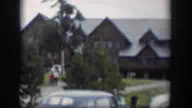Wyoming (1951): People Walking Near A House With Many Trees And An Old Blue Car
