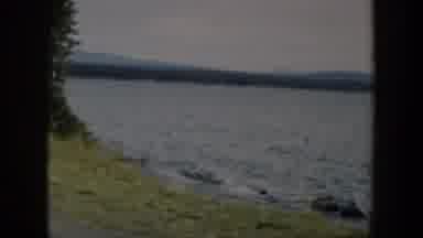 Wyoming (1951): The Coast Of A Lake With A Field Of Grass And Some Mountain Ranges