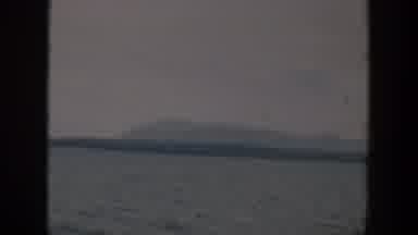 Wyoming (1951): View Of Pale Gray Mountain Silhouette And Ocean Water On A Cloudy