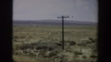 Wyoming (1951): Landscape Of Scrubby Field With Mountains In The Distance With A