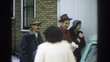 Michigan (1957): Man Wearing Gray Hat Looks At Green Car On A Clear Day