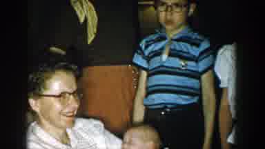 Michigan (1957): Boy Wearing Blue Shirt And Glasses Stands Near Girl Wearing Brown