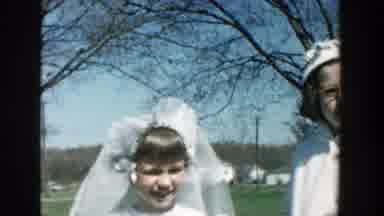 Michigan (1957): Two Kids And A Woman Are Wearing Formal White Clothing While