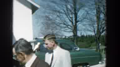 Michigan (1957): Adults Dressed In Suits And Dresses Stand Outside Talking Around