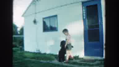 Michigan (1957): A Boy Plays With A Black Puppy In Front Of A White Painted