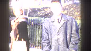 Washington DC-1960: Boy Wearing Black Coat Waves At Camera While Walking Behind Woman