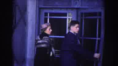 Washington DC (1960): Woman Wearing Black Coat Stands Near Yellow Hi-Boy Stall On