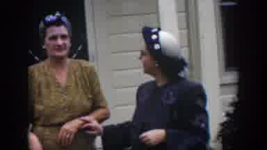 Cuba (1951): Two Women Wearing Glasses Walk Away From A White House On Clear Day