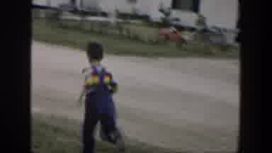 Cuba (1951): Boy Wearing Blue Overalls Runs Down Street On A Clear Day