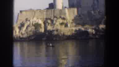 Cuba (1951): View Of Small Boat In Calm Water Near Tan Building On A Sunny Day