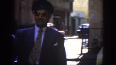 Cuba (1951): Man In A Black Suit And Sunglasses Walks Toward A Car While Man In
