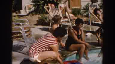 North Hollywood California (1962): Boy Wearing Red Shorts Sits Down To Put Feet In