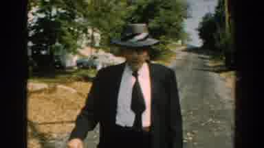 Michigan (1959): An Old Man Wearing A Suit And A Hat Walks With A Stick