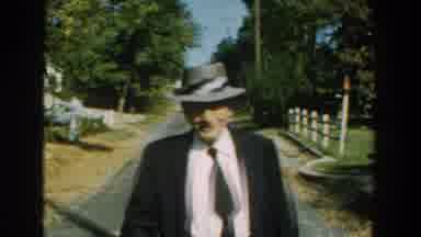 Michigan (1959): An Old Man Dressed In Suit And Wearing A Hat Approaches His Wife