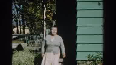 Michigan-1959: Grandma Walking Down Porch Picking Plants in Garden