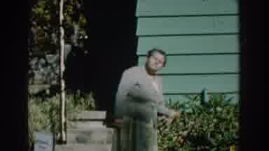 Michigan (1959): A Woman In Suit Checks Out A Flower Plant With A Smile