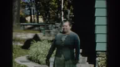Michigan (1959): A Woman In A Nice Jacket Walks Out Of The House With Her Son
