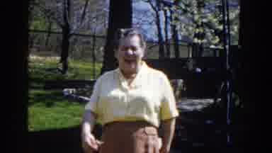 Michigan (1959): A Mature Woman Waves While Walking Forward Followed By A Car